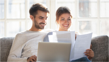 Couple sitting on couch together reviews their mortgage application.