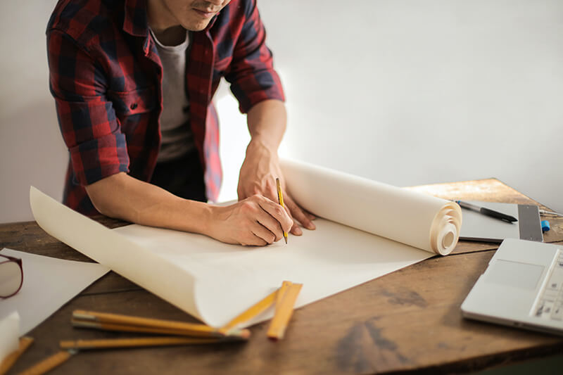 A renovation contractor drawing on the blueprints