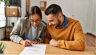 Couple sitting together at table considers fixed-rate mortgage paperwork.