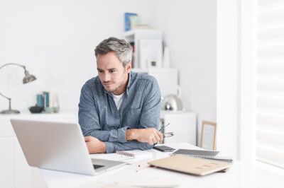 Man reads definition of escrow on computer in office.