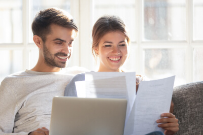Couple reads tax benefits of owning a home paperwork together.