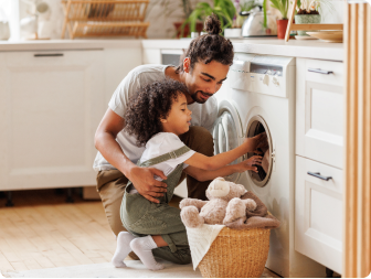 A father and daughter unload the dryer together in their energy-efficient home