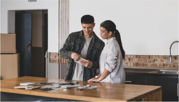 Couple reviews possible tile options for a kitchen renovation.